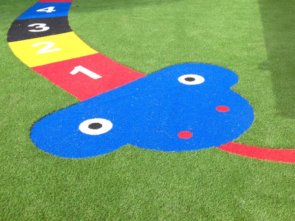 Lazylawn artificial grass being used for a snakes & ladders game in a playground