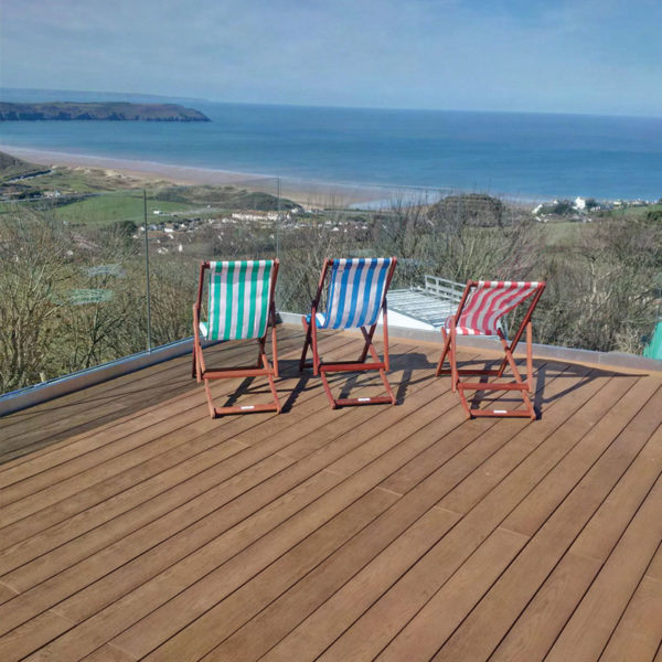 Millboard decking in coppered oak overlooking the sea