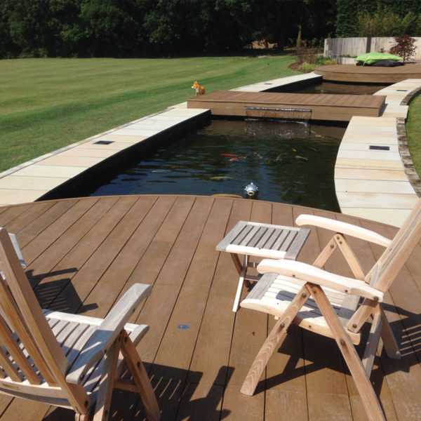 Coppered oak millboard decking by a pond