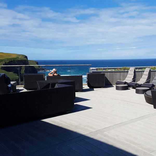 LazyLawn's Millboard decking in smoked oak looking over the sea