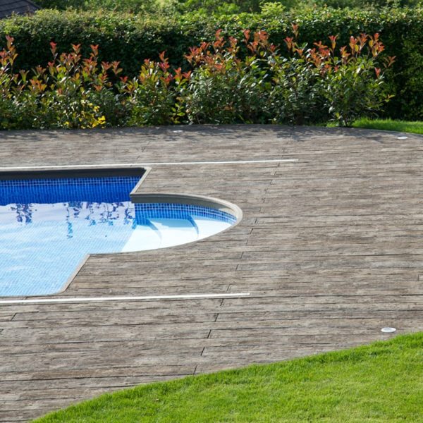 LazyLawn Millboard Decking in Vintage Weathered Oak by a swimming pool